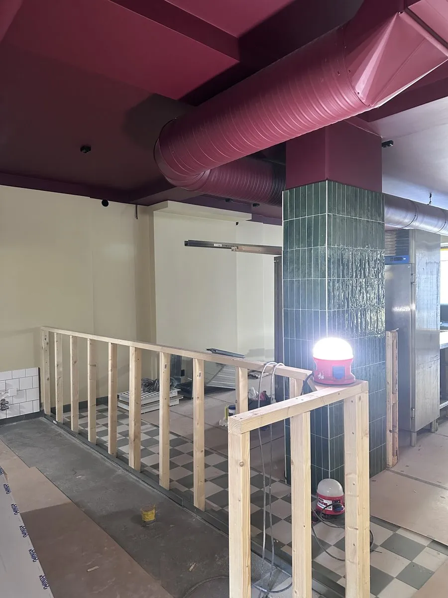 Den grönkaklade pelaren och den vinröda ventilationen under bygget