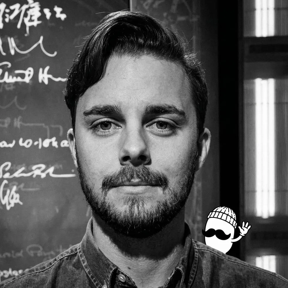 Andreas Jörnestrand i svartvitt framför en svart tavla full av krita